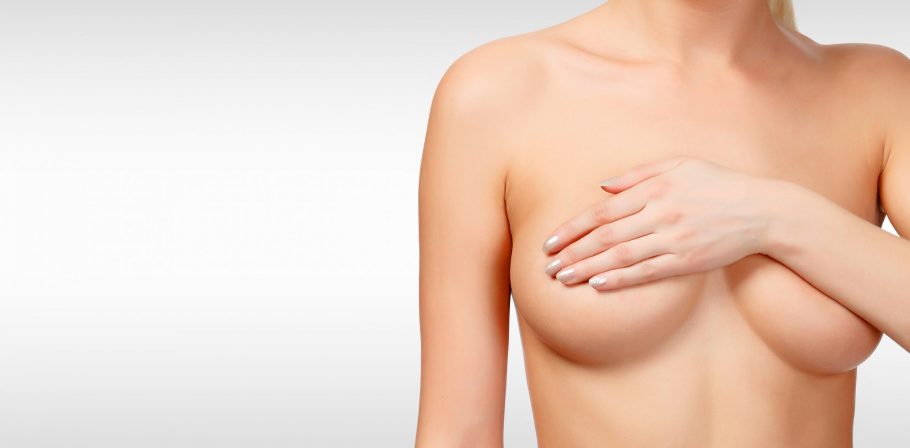 Woman controlling breast for cancer against a grey background with copyspace. Female healthcare con