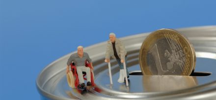 Kunststoff-Figuren, im Rollstuhl und mit Krücken auf Spardose